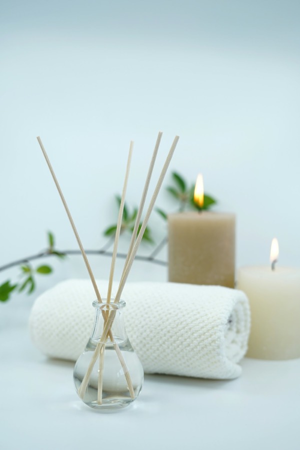 Difusor de aromas, toalla y velas encendidas