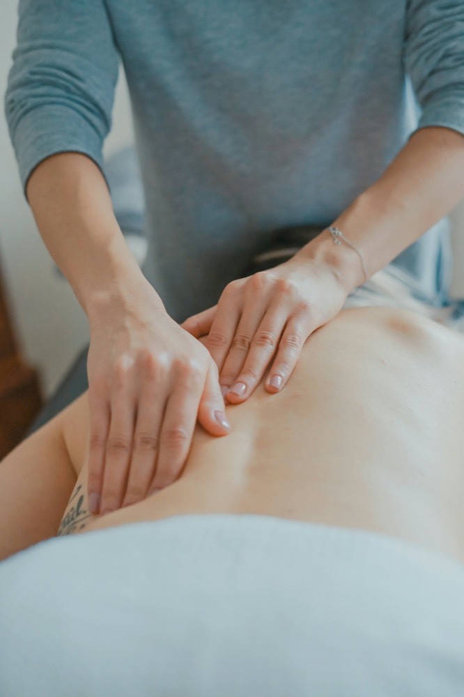 Manos de terapeuta dando un masaje de espalda