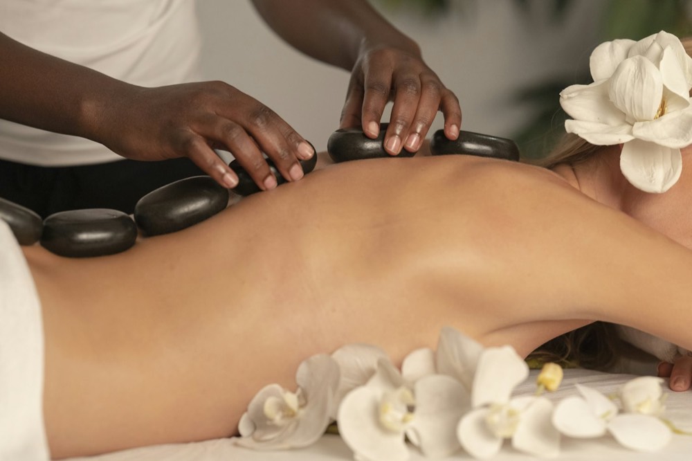 Masaje con piedras calientes y orquídeas blancas